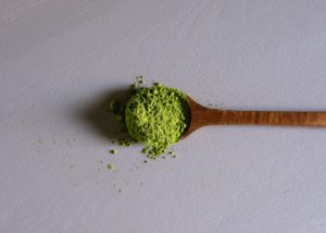 a wooden spoon filled with green powder